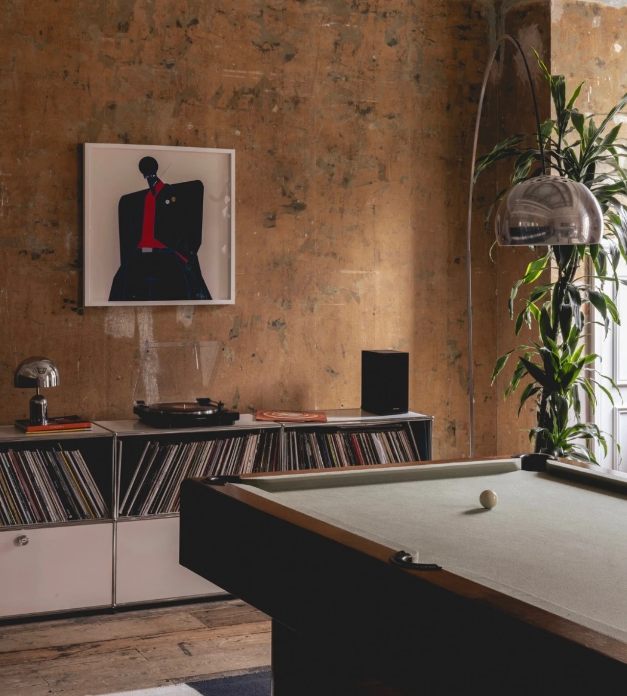 Venue lounge with a pool table, vinyl records, artwork, and an arched floor lamp