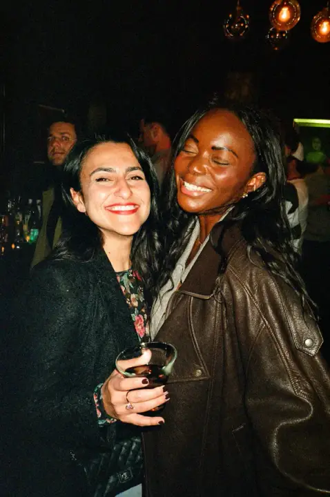 Two guests smiling together at the party